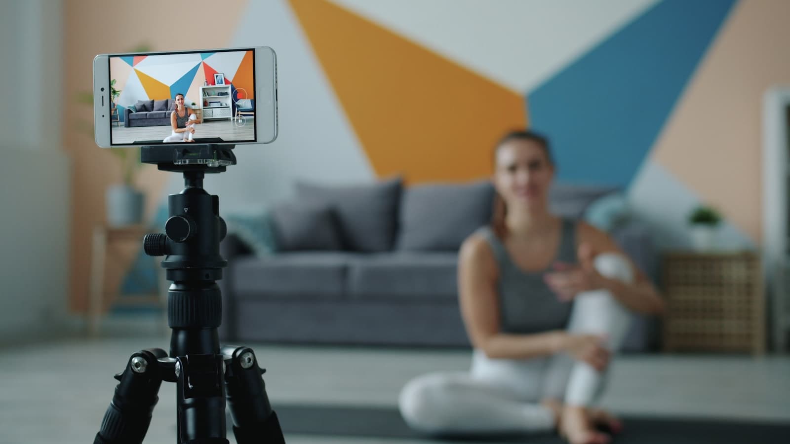 Woman recording a vertical video on her phone mounted on a tripod in a bright living room