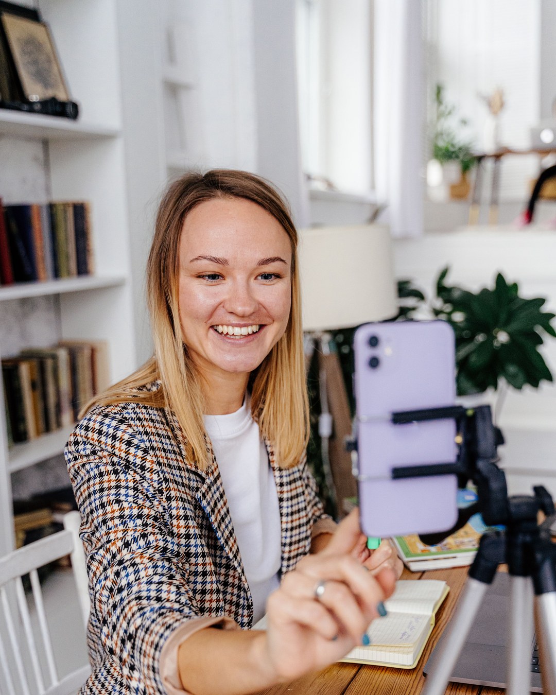 A creator filming herself on a phone tripod at home.
